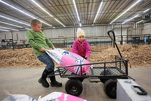 27102025
Hard-working siblings Elijah and Marren Ginter with BASKM Land & Cattle of Kelwood, Manitoba, unload cattle feed at their parents stalls in the Keystone Centre on Monday ahead of Manitoba AG EX, the all-breed cattle show that starts Wednesday and runs until Saturday.
(Tim Smith/The Brandon Sun)