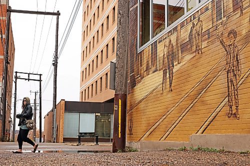 27102025
A pedestrian walking along Rosser Avenue passes by a mural outside Compass Credit Union on a rainy Monday morning. 
(Tim Smith/The Brandon Sun)