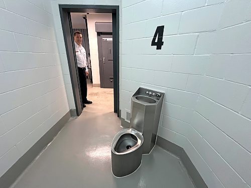 Brandon Police Chief Tyler Bates looks in the door of a holding cell at the recently constructed police detention faciliy at BPS headquarters on Victoria Avenue and 10th Street. Cells are small, holding a urinal and wash basin, as well as a mattress. (Matt Goerzen/The Brandon Sun)