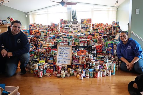 Scare Away Hunger, a family-run haunted house at Cedar Bay, organizers Mike (left) and Carla Mitchell kneel by over 3,000 food items received for Samaritan House at their haunted house in their living room on Sunday afternoon. Now in its third year, Scare Away Hunger is the brainchild of Mitchell, her husband Mike, and their daughters Emma, Claire, and Hannah. Every September, the family transforms their quiet Cedar Bay home into a labyrinth of spine-chilling scenes, complete with fog machines, eerie lighting and a skeletal grim reaper guarding the entrance. (Abiola Odutola/The Brandon Sun)