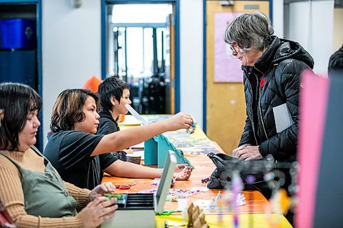 MIKAELA MACKENZIE / FREE PRESS

Marty Harper, 12, sells bracelets to Christine Skene at the craft sale table at the Rossbrook House open house on Thursday, Nov. 6, 2025.

Standup.
Free Press 2025