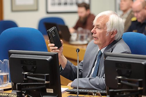 Coun. Barry Cullen (Ward 3) holds up his phone to the crowd to tell them about how much people rely on cell service. (Alex Lambert/The Brandon Sun)