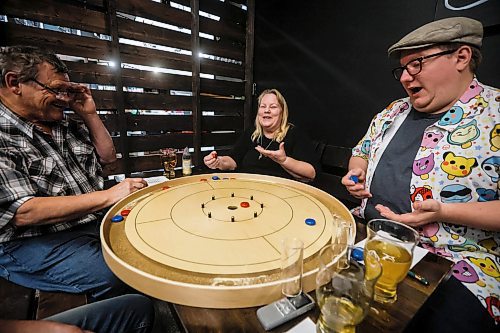 JOHN WOODS / FREE PRESS
Dave and Petra Johnson, from left, and Eathan Sveinson react to a shot during a bi-weekly crokinole meet up at a local downtown pub Monday, November 10, 2025.
Reporter: dave