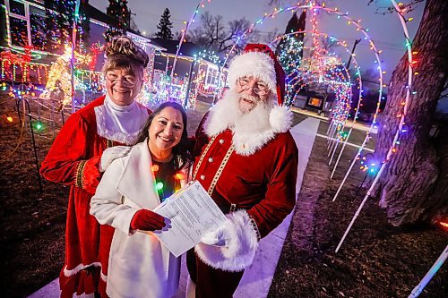 JOHN WOODS / WINNIPEG FREE PRESS
Brad and Roxanne Wallace, dressed as Santa and Mrs Claus, are photographed with city councillor Devi Sharma who assisted them in getting a permit for their Christmas light display that arches over the city sidewalk in front of their home in Winnipeg, Tuesday, November 25, 2025.
reporter: kevin