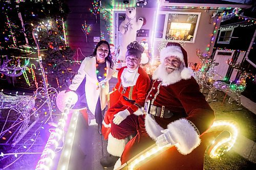 JOHN WOODS / WINNIPEG FREE PRESS
Brad and Roxanne Wallace, dressed as Santa and Mrs Claus, are photographed with city councillor Devi Sharma who assisted them in getting a permit for their Christmas light display that arches over the city sidewalk in front of their home in Winnipeg, Tuesday, November 25, 2025.

reporter: kevin