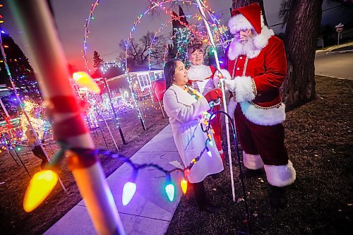 JOHN WOODS / WINNIPEG FREE PRESS
Brad and Roxanne Wallace, dressed as Santa and Mrs Claus, are photographed with city councillor Devi Sharma who assisted them in getting a permit for their Christmas light display that arches over the city sidewalk in front of their home in Winnipeg, Tuesday, November 25, 2025.

reporter: kevin