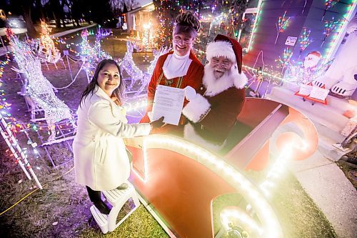 JOHN WOODS / WINNIPEG FREE PRESS
Brad and Roxanne Wallace, dressed as Santa and Mrs Claus, are photographed with city councillor Devi Sharma who assisted them in getting a permit for their Christmas light display that arches over the city sidewalk in front of their home in Winnipeg, Tuesday, November 25, 2025.

reporter: kevin