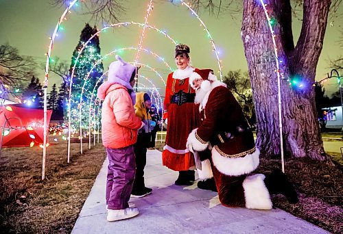 JOHN WOODS / WINNIPEG FREE PRESS
Brad and Roxanne Wallace, dressed as Santa and Mrs Claus, talk with local children in Winnipeg, Tuesday, November 25, 2025. Wallace received the assistance of councillor Devi Sharma in getting a permit for their Christmas light display that arches over the city sidewalk in front of their home.

reporter: kevin