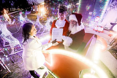 JOHN WOODS / WINNIPEG FREE PRESS
Brad and Roxanne Wallace, dressed as Santa and Mrs Claus, are photographed with city councillor Devi Sharma who assisted them in getting a permit for their Christmas light display that arches over the city sidewalk in front of their home in Winnipeg, Tuesday, November 25, 2025.

reporter: kevin