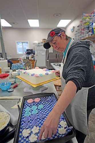 Courtney Jacobson, owner of Courtney's Cake Creations, decorates a cake in late November. (Connor McDowell/The Brandon Sun)