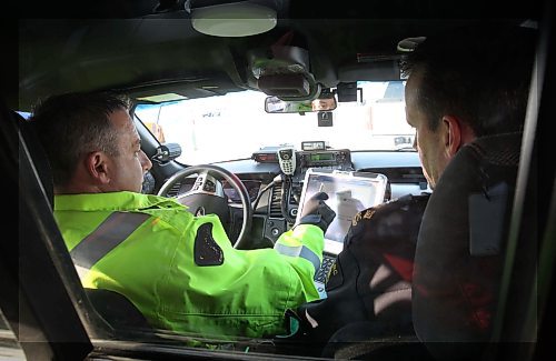 Const Shawn Smith , a RCMP Headingley officer dhows new technology installed in traffic enforcement police cars that will let officers issue e-Tickets to motorists committing infractions on Manitoba highways–During a traffic stop, an officer will swipe the driver’s licensee through a card reader- the offence will be added by the officer and a e-ticket is generated by the officer. Manitoba RCMP write aprx 34,00 Provincial Offence notices annually-Dec 08, 2014 (JOE BRYKSA / WINNIPEG FREE PRESS)