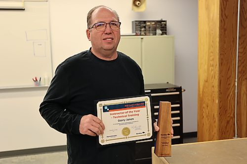 Assiniboine College electrical instructor Garry Jones holds the plaque and certificate presented to him as Apprenticeship Manitoba’s Instructor of the Year at the college's North Hill campus on Friday morning. (Abiola Odutola/The Brandon Sun)