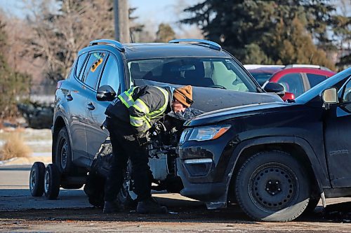 A tow-truck operator looks at the damage between a pair of SUVs at the scene of a two-vehicle collision during the noon hour at 18th Street and Richmond Avenue on Monday. (Matt Goerzen/The Brandon Sun)