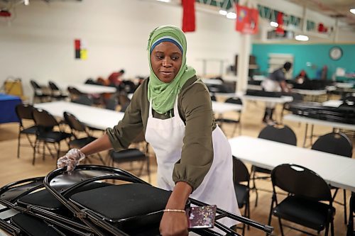 Volunteer Fatima Momoh stacks chairs after lunch was served at the Helping Hands soup kitchen on Friday. (Tim Smith/The Brandon Sun)