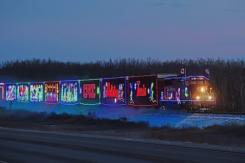 The CPKC Holiday Train heads west bordering Highway 16 as it makes its way to Shoal Lake at dusk on Friday for its final performance of the day. The train also made stops in Portage la Prairie, Neepawa and Minnedosa on Friday. (Tim Smith/The Brandon Sun)