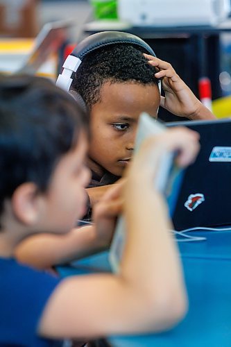 MIKE DEAL / FREE PRESS
Yoas Degefu, wearing headphones, listens and reads to a graphic novel, while Dacian Bateman-Jones-Lagos reads a printed graphic novel.
Yoas is Ethiopian and has only been here for about a month. His teacher, Russell Miller, will occasionally use AI to communicate in Amharic with him.
Russell Miller’s grade four class at Greenway School, 390 Burnell Street, where AI has come into play to help some students learn to read and for communication with some students who’s first language isn’t English.
Reporter: Maggie Macintosh
251209 - Tuesday, December 09, 2025.
