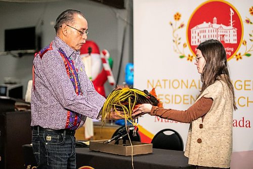 MIKAELA MACKENZIE / FREE PRESS
Long Plain band councillor (and grandson of chief Angus Merrick) Randy Merrick (left) accepts the headdress from Fort la Reine Museum representative Caitlin Post in a repatriation ceremony for the sacred object at Long Plain First Nation urban reserve near Portage la Prairie on Tuesday, Dec. 16, 2025.
For CP story.
Free Press 2025