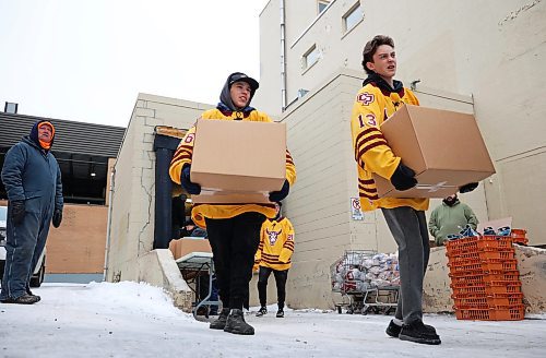 Volunteers carry hampers outside to be loaded into waiting vehicles. (Tim Smith/The Brandon Sun)