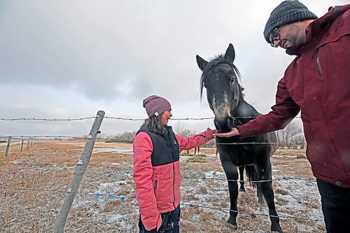 Blake Smart feeds a horse a candy cane with her dad, Andrew. (Connor McDowell/The Brandon Sun)