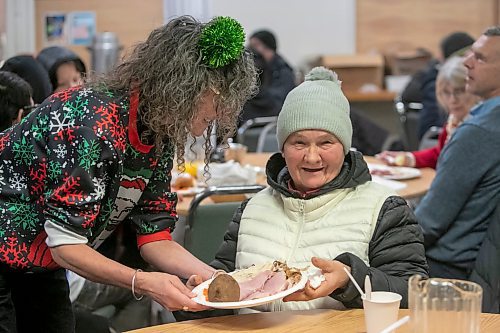 BROOK JONES/FREE PRESS
As many as 600 meals were expected to be given out during a Christmas dinner at Mission Baptist Church in Winnipeg, Man., Thursday, Dec. 25, 2025. Pictured: Bonnie Ferguson-Baird (left) serves a Christmas dinner to Valentina, 73.