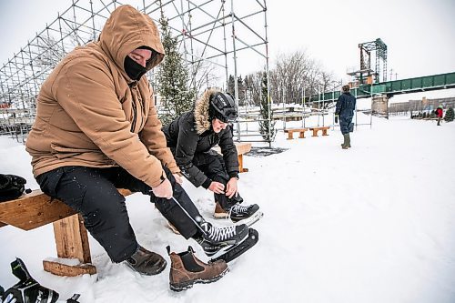 MIKAELA MACKENZIE / FREE PRESS

Maxwell Hayward (left) and Angela Gaiero lace up their skates on the Nestawaya river trail on opening day on Thursday, Jan. 1, 2026. The tourists from Ontario were excited that their flight later in the afternoon was delayed by close to an hour, giving them a chance to skate on the river right before flying home.

For Melissa story.
Free Press 2026