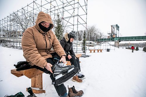 MIKAELA MACKENZIE / FREE PRESS

Maxwell Hayward (left) and Angela Gaiero lace up their skates on the Nestawaya river trail on opening day on Thursday, Jan. 1, 2026. The tourists from Ontario were excited that their flight later in the afternoon was delayed by close to an hour, giving them a chance to skate on the river right before flying home.

For Melissa story.
Free Press 2026