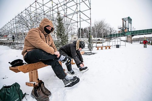 MIKAELA MACKENZIE / FREE PRESS

Maxwell Hayward (left) and Angela Gaiero lace up their skates on the Nestawaya river trail on opening day on Thursday, Jan. 1, 2026. The tourists from Ontario were excited that their flight later in the afternoon was delayed by close to an hour, giving them a chance to skate on the river right before flying home.

For Melissa story.
Free Press 2026