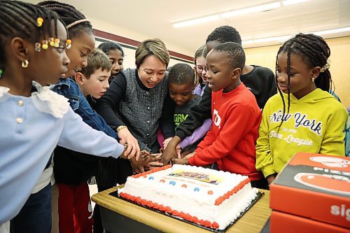 Wing Chow, music teacher at École New Era School, cuts a cake with her Grade 3 music students to celebrate their first-place CBC Music Class Challenge Culture Award win in the non-western instrument category. The students celebrated with pizza and cake on Tuesday. See story on Page A2. (Tim Smith/The Brandon Sun)