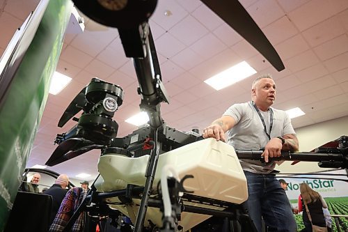20012026
Travis Karle, President and CEO of Ag Drone Canada, leans over a Spider-i M400 agricultural drone while speaking with visitors to Ag Drone Canada’s booth at Manitoba Ag Days 2026 on Tuesday. 
(Tim Smith/The Brandon Sun)