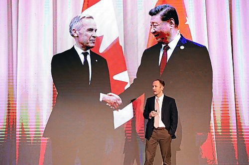 Geopolitical analyst Jacob Shapiro stands before an image of Prime Minister Mark Carney shaking hands last week with Chinese President Xi Jinping during his talk in the Keystone Centre as part of Manitoba Ag Days 2026 on Wednesday. (Tim Smith/The Brandon Sun)