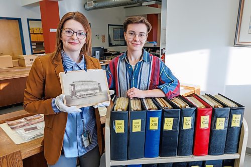 MIKE DEAL / FREE PRESS
Sarah Ramsden (left), senior archivist, and Gwen Friesen (right), archival intern at the City of Winnipeg Archives, with the binders with yellowing pages in which many of the photos were stored in for decades at the transit offices.
Sarah is holding one of the photos depicting Winnipeg Electric Street Railway streetcar No. 10 on the St. Johns–Kildonan route, ca. 1892–1904 (City of Winnipeg Archives, Box A2266, File 62, Item 4.)
Reporter: 
260122 - Thursday, January 22, 2026.