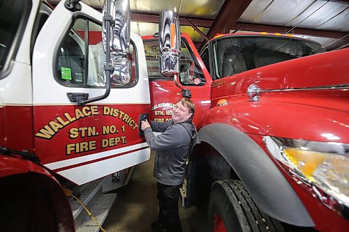 Wallace District Station 1 Fire Chief Cory Nixon opens two doors on fire trucks in the Virden hall to show how cramped space leads to difficulty loading trucks during emergency calls. (Connor McDowell/The Brandon Sun)