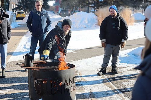 Brandon University's Ian Puppe places the frying pan on fire during the outdoor cooking session in the university's Kavanagh Courtyard on Friday afternoon. Puppe and others teach students how to make Bannock or fry bread, a popular food typically made with flour, baking powder, water, salt and sometimes sugar, cinnamon or raisins. Photos: Abiola Odutola/The Brandon Sun