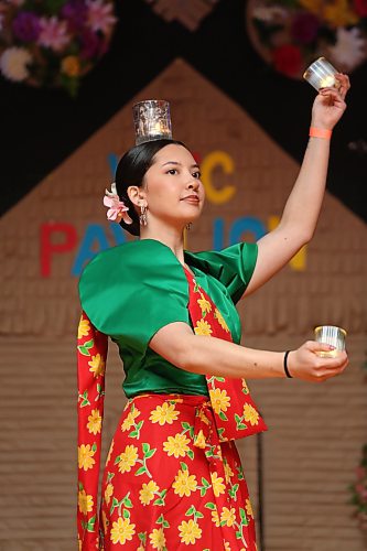A young Filipino woman dressed in traditional clothes performs a dance with candles on stage at the Philippines pavilion on Friday evening. (Matt Goerzen/The Brandon Sun)