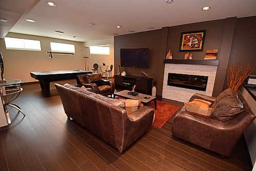 Todd Lewys / Free Press
A media area with stone-trimmed electric fireplace serves as the hub of the rec room, which also offers a workout space and games area.