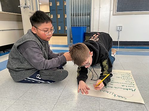 Milo Dooley, 10, tallies different types of waste that his peers have discarded in recent weeks, alongside 11-year-old Mark Quierre. MAGGIE MACINTOSH/FREE PRESS