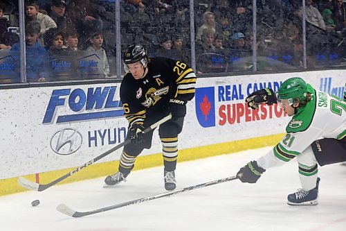Luke Mistelbacher works to keep the puck away from Raiders' Evan Smith. (Tim Smith/The Brandon Sun)