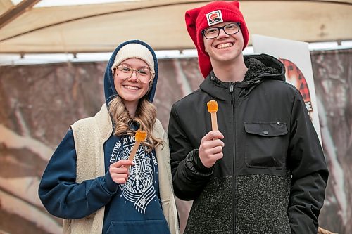 BROOK JONES/FREE PRESS
Chloe Zirk, 18, (left) and her brother Nolin Zirk, 16, are all smiles after making frozen maple taffy on a stick in the Sugar Shack on the final day of the 57th edition of Festival du Voyageur in Saint Boniface, Man., Sunday, Feb. 22, 2026.