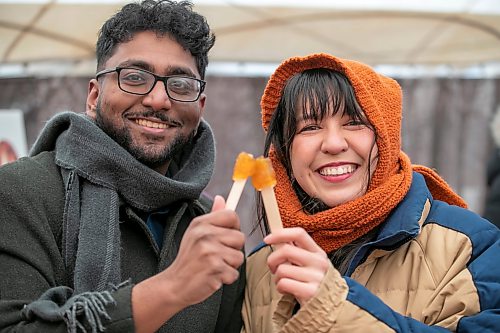 BROOK JONES/FREE PRESS
Ashwin Gnanabaskaran (left) and his friend Rebecca Fung are all smiles after rolling frozen maple taffy on a stick in the Sugar Shack on the final day of the 57th edition of Festival du Voyageur in Saint Boniface, Man., Sunday, Feb. 22, 2026.