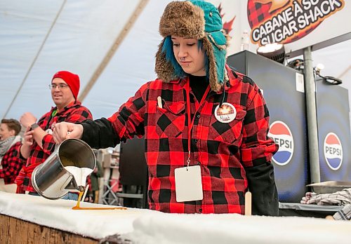 BROOK JONES/FREE PRESS
Volunteer Noah Gott is pictured pouring hot maple syrup for rolling frozen maple taffy on a stick in the Sugar Shack on the final day of the 57th edition of Festival du Voyageur in Saint Boniface, Man., Sunday, Feb. 22, 2026.