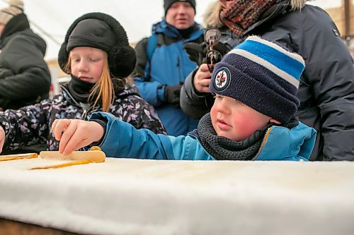BROOK JONES/FREE PRESS
Rhys Leslie, 5, (right) and his sister Blake Leslie, 9, are pictured rolling frozen maple taffy on a stick in the Sugar Shack on the final day of the 57th edition of Festival du Voyageur in Saint Boniface, Man., Sunday, Feb. 22, 2026.