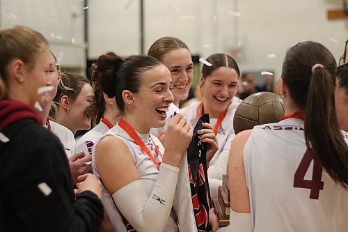 Heather Brost clutches the MCAC women's volleyball championship banner. (Thomas Friesen/The Brandon Sun)