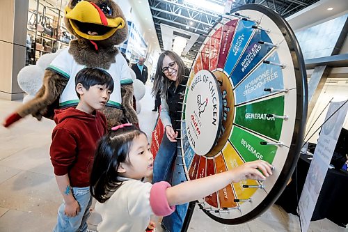 JOHN WOODS / FREE PRESS
Siblings Daniel and Chelsea spin the Manitoba Chicken Producers trivia Wheel of Chicken with Evy Wiebe, a Manitoba chicken farmer, at the Discover Agriculture In The City educational event showcasing Manitoba agriculture and agri-food sector at Outlet Collection Sunday, March 15, 2026. 


reporter: standup