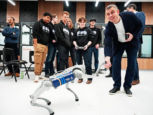 Scotlin Priestley, a first-year mechatronic student, uses a controller to demonstrate his robotic dog, Otto, to Andriy Hoydalo, sales manager from Greenstone Building Products, during the PrairiesCan announcement ceremony at Assiniboine College’s North Hill Campus on Thursday. (Weichen Zhang/The Brandon Sun )