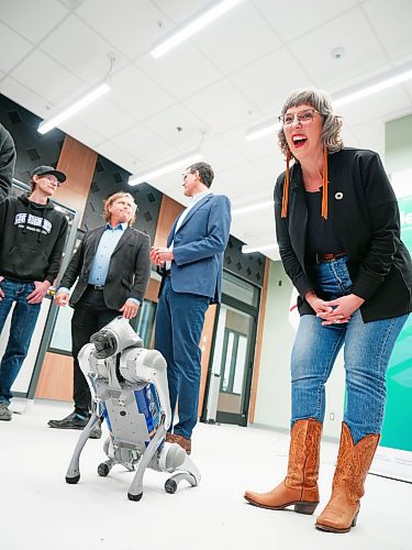 Ginette Lavack, MP for St. Boniface-St.Vital, reacts with delight as robotic dog Otto performs during the PrairiesCan announcement ceremony at Assiniboine College’s North Hill Campus on Thursday. (Weichen Zhang/The Brandon Sun )