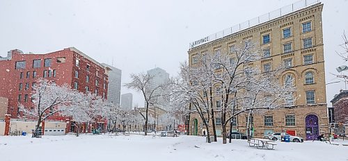 MIKE DEAL / FREE PRESS
Snow falls as pedestrians make their way through the Exchange District Wednesday morning.
260408 - Wednesday, April 08, 2026.