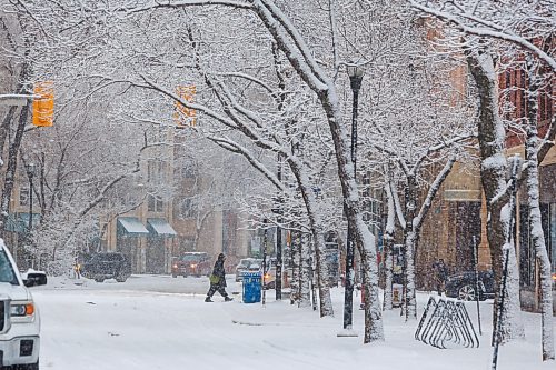 MIKE DEAL / FREE PRESS
Snow falls as pedestrians make their way through the Exchange District Wednesday morning.
260408 - Wednesday, April 08, 2026.