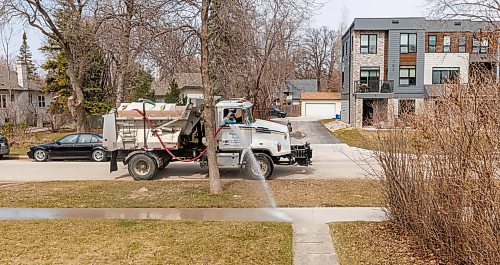 MIKE DEAL / FREE PRESS
A water truck and a sidewalk cleaner work their way through the Point Road neighbourhood Thursday afternoon.
260423 - Thursday, April 23, 2026.