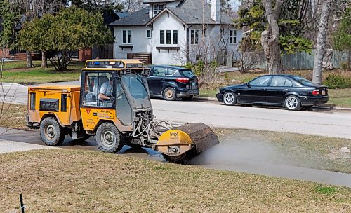 MIKE DEAL / FREE PRESS
A water truck and a sidewalk cleaner work their way through the Point Road neighbourhood Thursday afternoon.
260423 - Thursday, April 23, 2026.