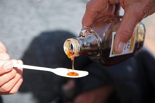 Visitors sample maple syrup made from sap collected from Manitoba maple trees tapped on the adjoining properties owned by the Brandon Food Forest and Dave Barnes on Thursday. The sap is heavily boiled down to become syrup. (Tim Smith/The Brandon Sun)